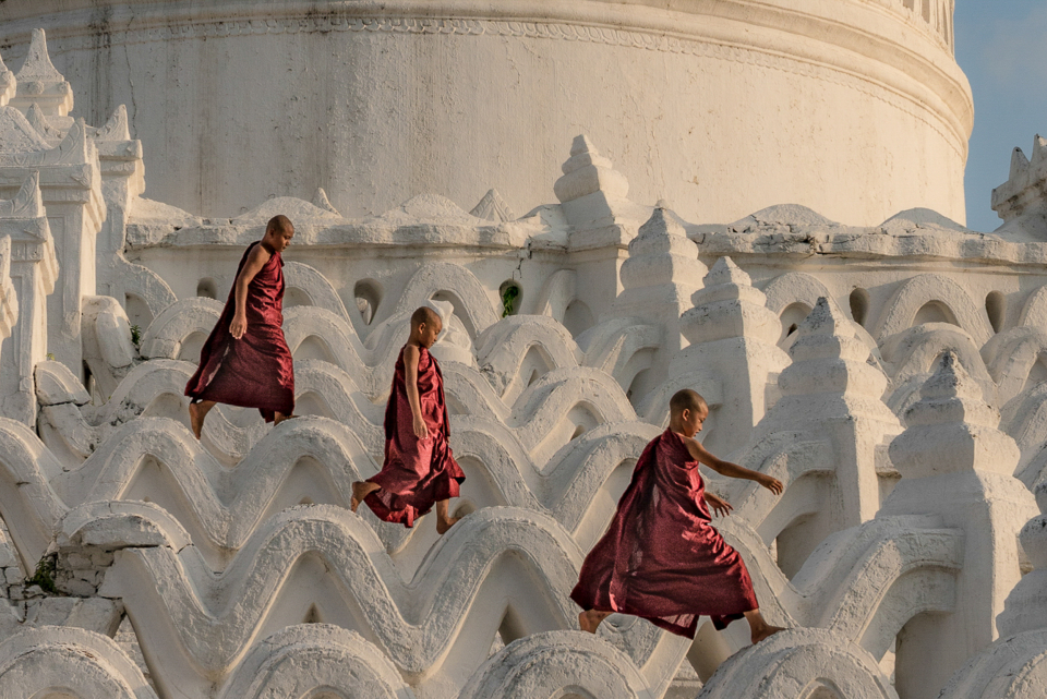 Travel and culture category three young children walk along a uniquely structured building in Myanmar, photographed by Laura Menesini